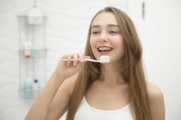 portrait-young-smiling-girl-cleaning-her-teeth_1163-2269